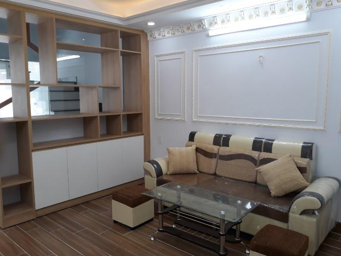 Phòng khách nhà phố Quang Trung, Gò Vấp Nhà phố hướng Đông Nam, xe hơi đậu trong nhà, có công viên nhỏ.